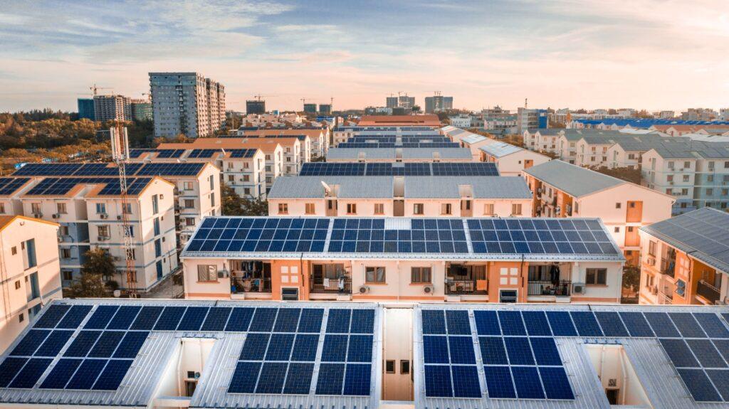 Luftaufnahme von Wohngebäuden in Köln mit Photovoltaikanlagen auf den Dächern, die Solarenergie für die Stadt produzieren und zur Reduzierung von CO2-Emissionen beitragen.